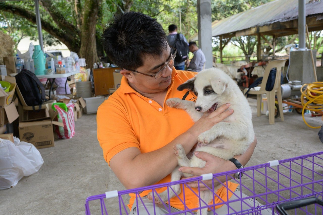 A man cuddling with a dog