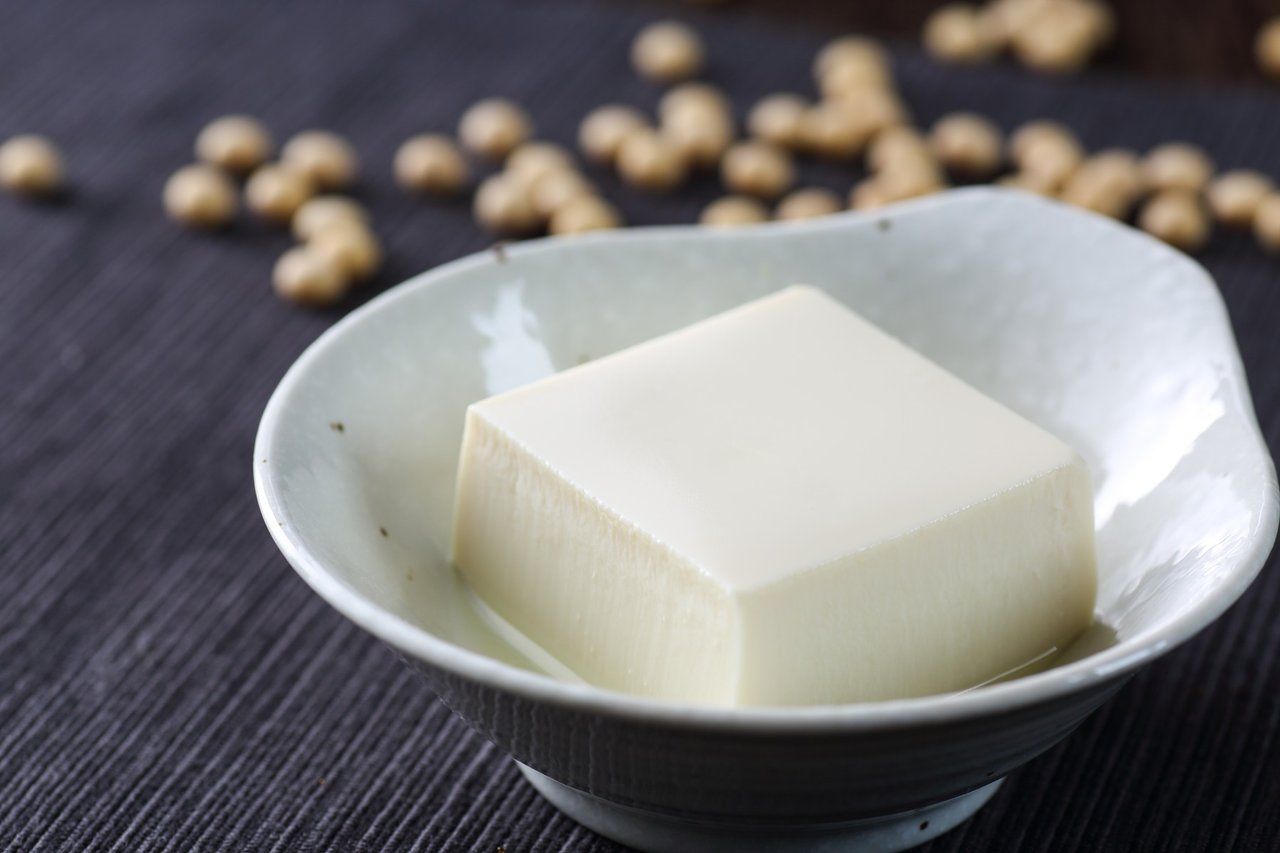 silken tofu in a bowl surrounded by soy beans