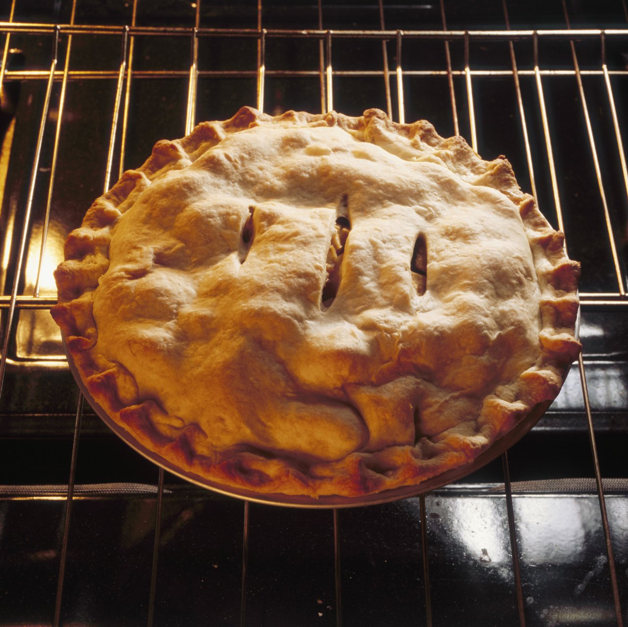 apple pie baking on an oven rack