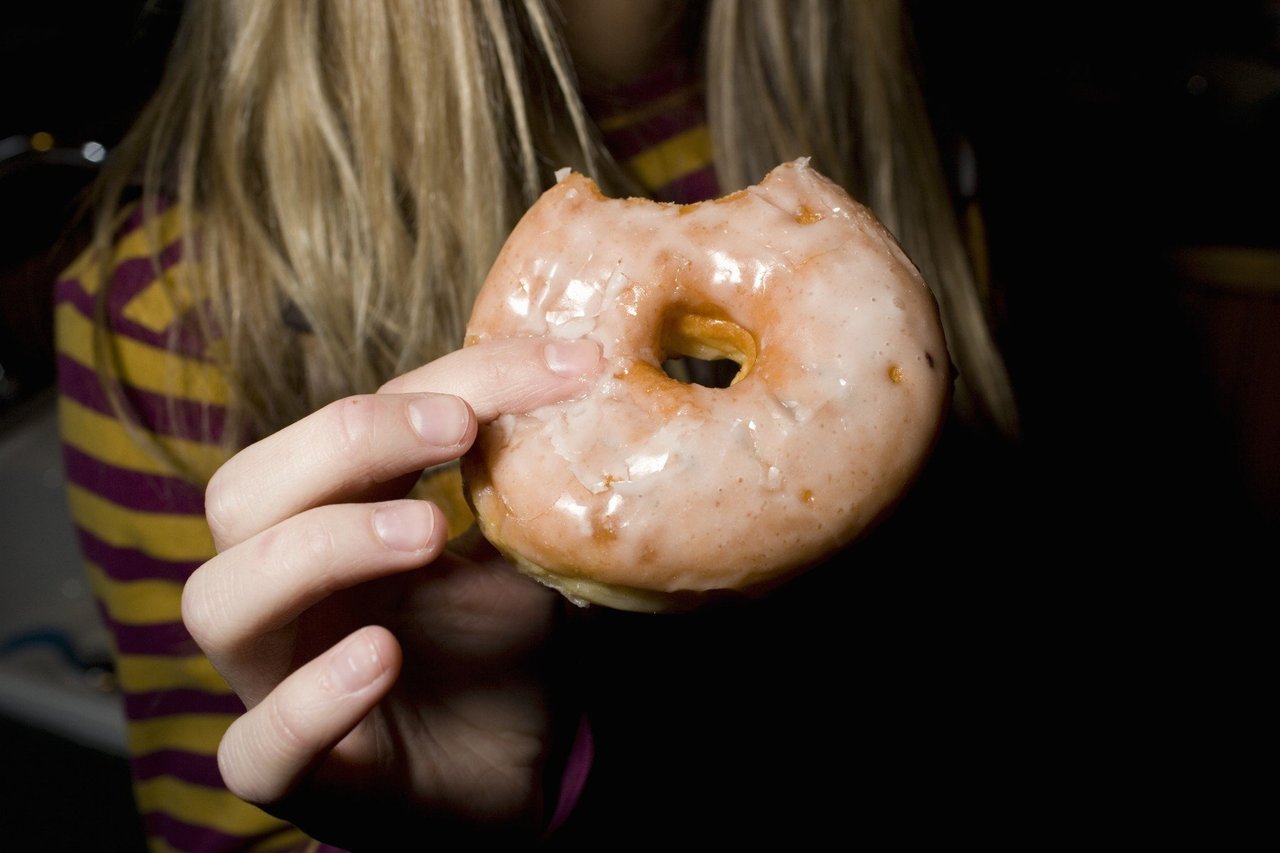 hand holding a vegan glazed donut
