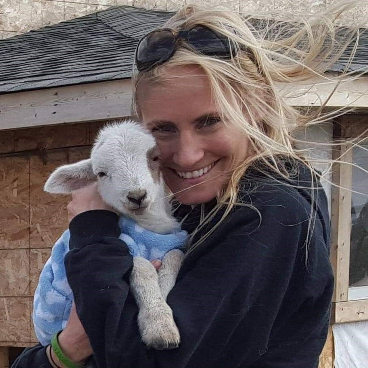 lindsay oliver executive director cuddling a lamb