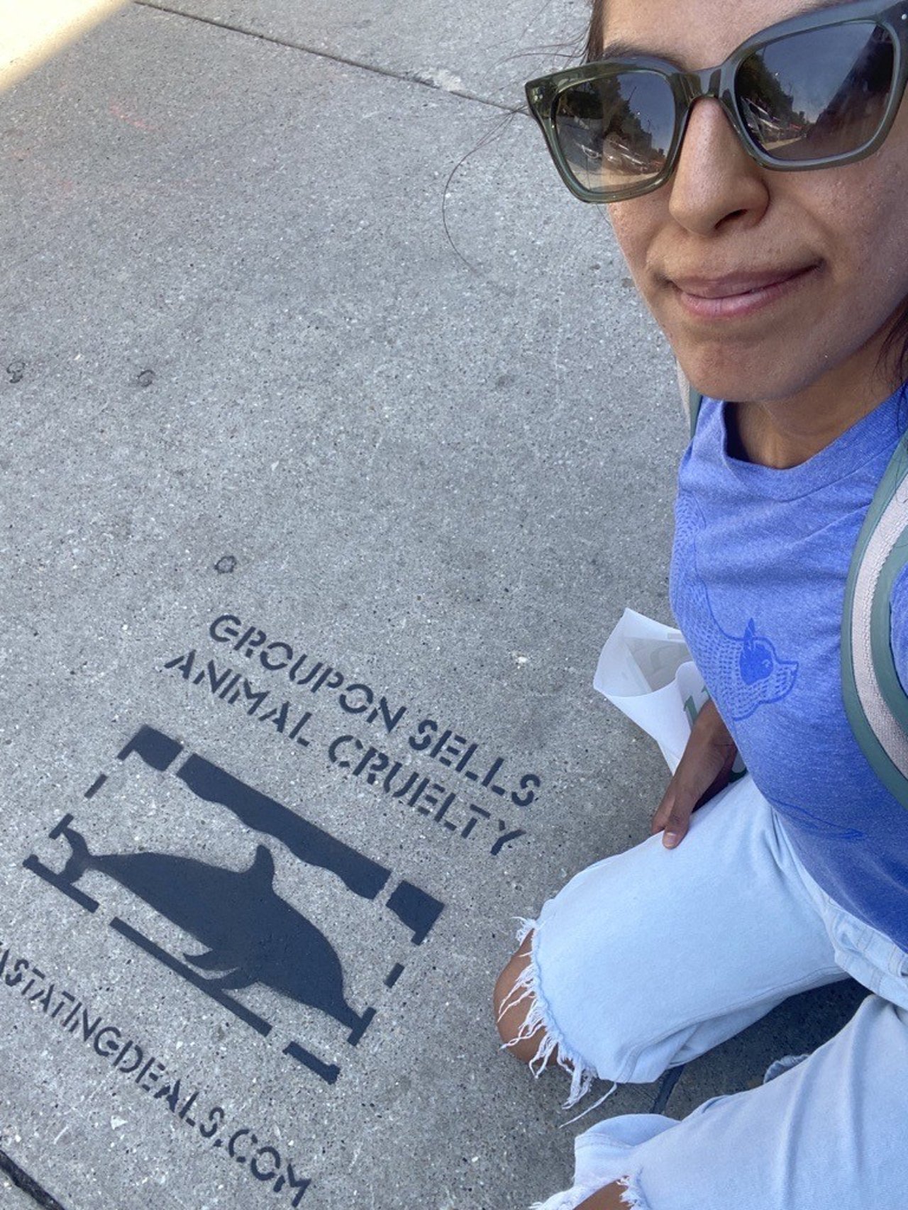 Nicole Barrantes posing with a sidewalk stencil for her Groupon campaign