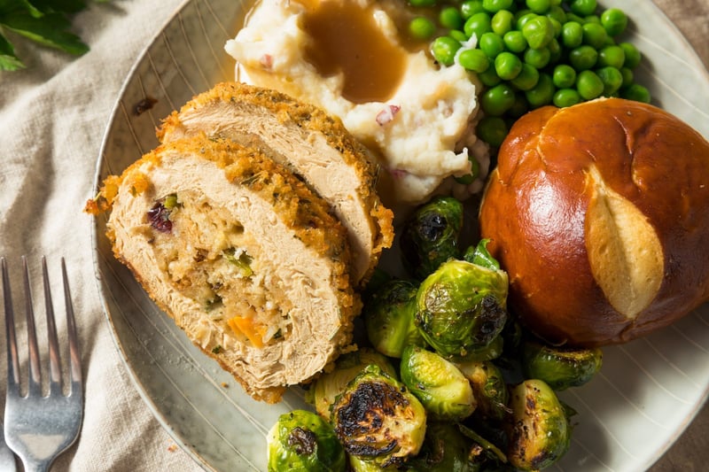 plate full of vegan turkey, brussels sprouts, bread, and peas