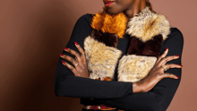 A model with red nails, red lips and a faux fur coat.