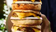 A person holding a breakfast sandwich.
