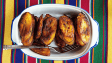 Fried plantains in a dish on a striped tablecloth.
