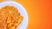 A bowl of red lentils overlayed on an orange background.