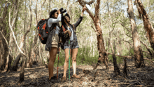Two women bird watching in a forest.