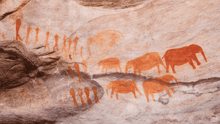 A cave painting of humans and animals.