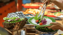A vegan buffet, with one diner serving salad onto their plate.