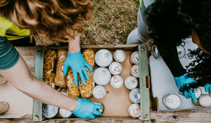 People packing canned goods for donation to a food bank.