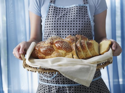 person holding a platter of vegan challah bread
