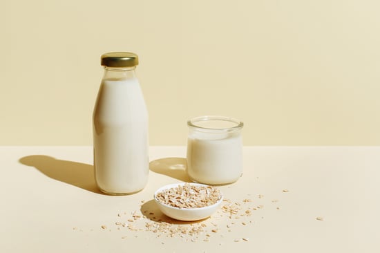 Oatmilk and oats on a cream background.