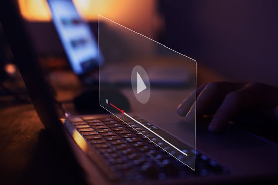 A composite image of a laptop with a computer window over top and a play button.
