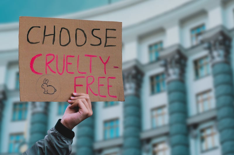 A protestor holding a sign at a protest that says "Choose Cruelty-Free."