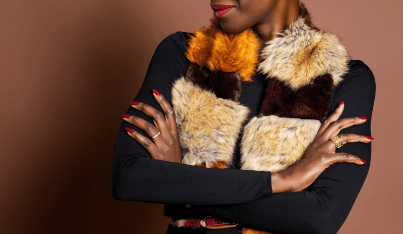 A model with red nails, red lips and a faux fur coat.